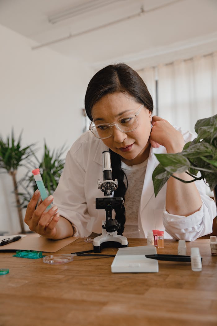 Asian female scientist examines a test tube sample in a modern laboratory.